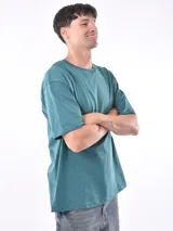 Remera de corte oversized en color verde petróleo, con cuello redondo y mangas cortas.