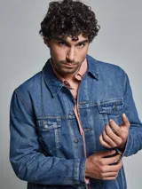 Campera de jean azul de corte regular, con lavado medio, dos bolsillos en la pechera con tapita y dos bolsillos inferiores.