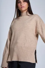 Sweater color crema de media polera, corte holgado y mangas largas. Tejido de punto con detalles acanalados en cuello, puños y ruedo.