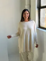 Sweater de punto color crudo, con cuello redondo, manga larga y diseño holgado con costura central vertical.