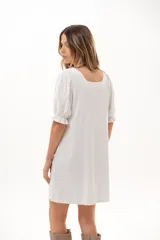 Vestido corto blanco de corte evasé, con escote cuadrado y mangas cortas abullonadas.