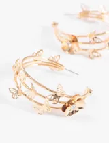 Aros tipo argolla dorados con apliques de mariposas y flores.