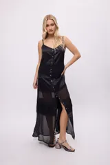 Vestido largo blanco con breteles finos, corte amplio y paneles de encaje.