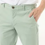 Pantalón chino de corte slim, color verde menta, con cierre de botón y cremallera, bolsillos laterales y bolsillos traseros tipo ojal.