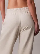 Jogger de felpa de mezcla de algodón en color beige, con cintura elástica, bolsillos laterales, puños en los tobillos y monograma CK estampado en la pierna izquierda.