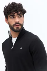 Sweater de tejido de punto color negro, con cuello alto y cierre frontal parcial plateado. Presenta un pequeño logo bordado en el pecho y cuello interior de color gris.