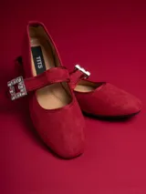 Chatitas negras de gamuza con correa sobre el empeine y hebilla con strass.