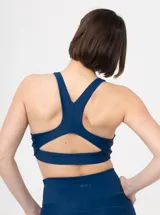 Top deportivo azul con espalda estilo nadador y aberturas geométricas.