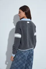 Campera de punto tipo cardigan en color bordó, con cierre frontal, cuello redondo y diseño estilo universitario. Presenta el número 54 bordado en blanco en el pecho y franjas blancas en las mangas.