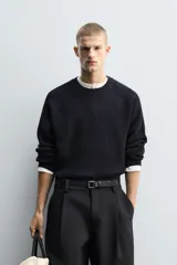 Jersey de punto con diseño boxy fit, cuello redondo y manga larga. Presenta una textura acanalada y acabados en rib en cuello, puños y ruedo.