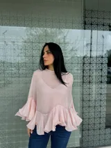Blusa color rosa pálido de gasa con volados en las mangas y en el ruedo.