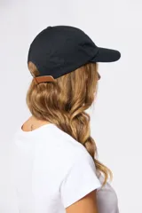 Gorro con visera de lona rosado con bordado frontal en tonos verde y violeta.