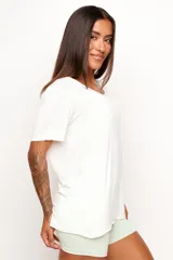 Remera de corte holgado y diseño minimalista, confeccionada en una mezcla de viscosa, lino y elastano. Presenta cuello redondo amplio y mangas cortas con terminación al corte.