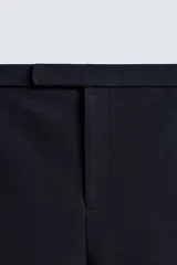 Shorts de corte sastrero confeccionados en tejido de piqué elástico, con cierre frontal de cremallera y gancho metálico oculto, y bolsillos laterales.