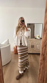 Pollera tejida a rayas horizontales en tonos beige, marrón y blanco.