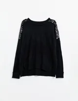 Buzo de tejido de punto color negro, con cuello redondo y mangas largas. Apliques de lentejuelas en los hombros. Marca Q2.