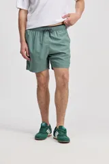 Short de baño azul, de corte clásico y largo corto, con cintura elástica y cordón ajustable bicolor. Cuenta con bolsillos laterales y uno trasero.