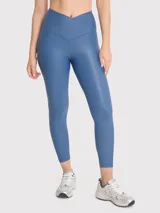 Calza deportiva de tiro alto con cintura en forma de V, confeccionada en tela brillante de efecto segunda piel. Presenta un diseño liso y ajuste regular.