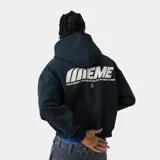 Hoodie oversize color azul marino con estampado gráfico en la espalda que dice "EMEME" en blanco, acompañado del texto "EMESTUDIOS / THE PULSATIONS OF AN UNRULY SCENE" y un pequeño logo circular debajo.