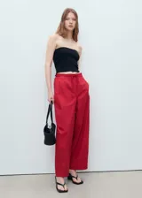 Pantalón rojo de corte holgado y pernera ancha, con cintura elástica fruncida y cordón ajustable.