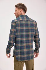 Camisa de manga larga con cuello y botones, confeccionada en tejido de franela a cuadros en tonos verde oscuro, azul marino y marrón.