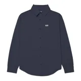 Camisa de manga larga color azul marino, con cuello camisero, cierre frontal de botones y bolsillo en el pecho con etiqueta de la marca. Presenta un diseño versátil con mangas convertibles.