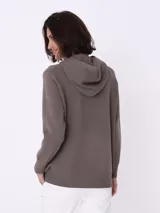 Sweater con capucha color visón, de tejido de punto con cordones ajustables, bolsillo tipo canguro y terminaciones acanaladas.