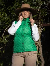 Chaleco capitoneado color rosa claro, con cuello alto, cierre frontal con botones a presión y logo bordado en el pecho.