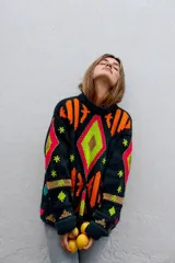 Sweater de punto tejido a mano con diseño multicolor de patrones geométricos y detalles bordados, de corte holgado y mangas largas.