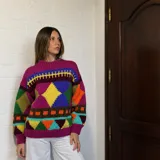 Sweater de lana merino con estampado Fair Isle en tonos azul marino, beige, naranja, verde oliva y bordó. Tiene cuello redondo y mangas largas.