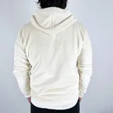 Canguro color crema de tela peluche con capucha, cierre de cremallera corto y bolsillo tipo canguro. Logo de la marca bordado en negro en el pecho.