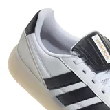 Championes Adidas modelo Barreda, de diseño urbano con capellada en cuero sintético blanco, icónicas tres tiras laterales en negro y suela de goma traslúcida tipo cupsole.