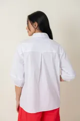 Camisa blanca de algodón, manga tres cuartos ancha con frunce y calce holgado.