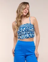 Top crop de viscosa con estampado abstracto en tonos azul y blanco, con pechera integramente elastizada en punto smock, escote recto y breteles finos.