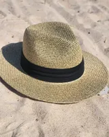 Sombrero de playa de paja color beige con cinta negra y protección UV.