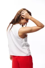 Blusa blanca sin mangas con detalles de encaje en el ruedo y los hombros.