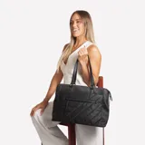Bolso tipo tote negro con diseño acolchado en diagonal, doble asa de mano y cierre superior.