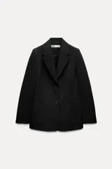 Blazer negro de Zara Woman Collection, con cuello solapa, manga larga con abertura y botones, bolsillos de plastrón en delantero, forro interior a tono y cierre frontal con botones.