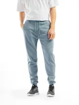 Pantalón deportivo de felpa color celeste/azul claro jaspeado, con cintura ajustable mediante cordón y puños elásticos en los tobillos.