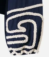 Blusa corta de algodón color azul marino, con escote cuadrado, mangas largas abullonadas y detalle de bordado en cuerda blanca en los puños.