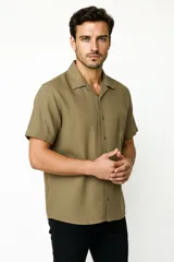 Camisa de manga corta color verde militar, con cuello camisero y cierre frontal de botones.
