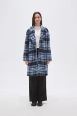 Tapado largo de poliéster con estampado a cuadros en tonos azules y negro. Presenta un diseño holgado con cuello de solapa, manga larga y bolsillos laterales.