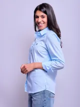 Camisa de vestir entallada a rayas verticales celestes y blancas, de manga larga y cuello clásico.