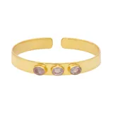 Brazalete rígido dorado con tres piedras ovaladas de cuarzo rosado.