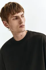 Remera negra de punto de algodón pesado, con cuello redondo ribeteado acanalado, hombros caídos y mangas cortas de corte holgado.