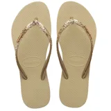 Sandalias tipo ojotas Havaianas modelo Slim Glitter II, color beige arena, con tiras finas cubiertas de glitter dorado y logo de la marca en relieve.