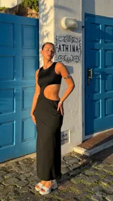 Vestido largo negro con corte en la cintura y abertura lateral.