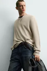 Jersey relaxed fit de punto acanalado color marrón oscuro, con cuello redondo tipo panadera y cierre frontal de tres botones. Tiene manga larga y efecto lavado.