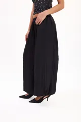 Pantalón marrón fluido de corte ancho y relajado, con cintura elástica fruncida y diseño abombado en las piernas.