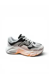 Championes deportivos de estilo chunky, color beige con detalles en negro y gris, con suela gruesa texturizada.